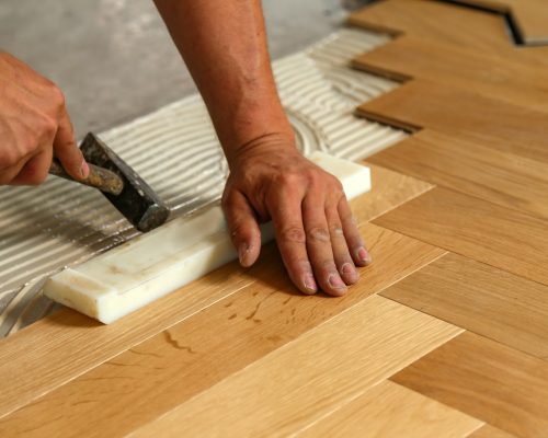 Worker installing parquet flooring